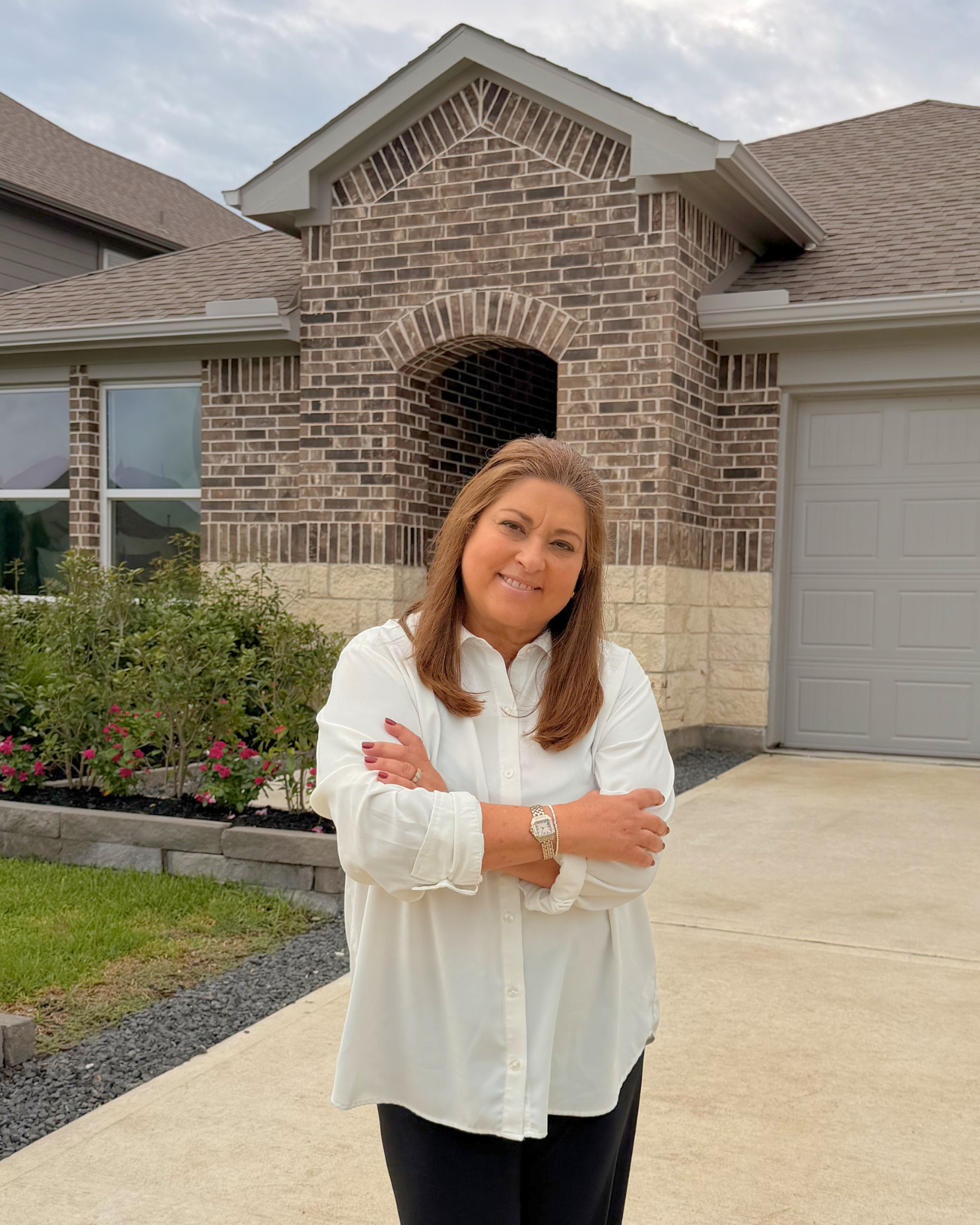 Marianela De Pinho, Mary D Realtor, in front of a new construction home